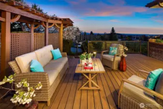 Twilight deck — soft sky glow, distant Mount Rainier silhouette, cool evening breeze, and warm lights as the horizon blushes for lingering conversations.
