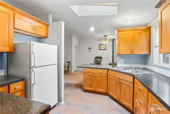 Kitchen w/Newer Cabinets, Laminate Counters, Vinyl Flooring and Skylight. Fridge stays!