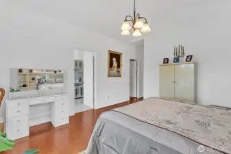 Primary suite features hardwood floors, vaulted ceilings, walk in closet and spa inspired primary bathroom.