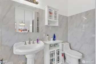 Primary bathroom with pedestal sink, elongated lavatory and walk in shower.
