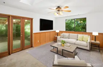 Virtually staged family room with double doors to  the back patio.