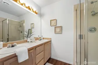 Primary bathroom features double sinks a lovely glass enclosed shower.