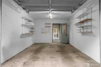 The individual garage has built-in shelves. Great for parking and/or storage. That next door straight ahead is the entrance to the home.