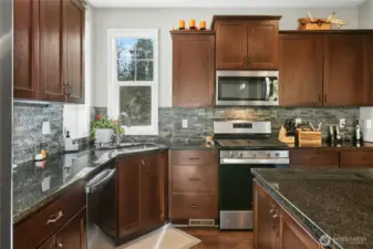 Kitchen:  A beautiful blend of style and function, this kitchen features rich cabinetry, granite countertops, stainless steel appliances, and a sleek tile backsplash. Natural light highlights every detail, creating a warm and welcoming space perfect for cooking, conversation, and connection.