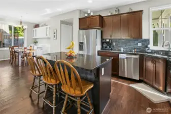 Kitchen & Dining:  Designed for connection and comfort, this kitchen flows easily into the dining area, creating a bright and open atmosphere. The large island with seating invites conversation, while rich cabinetry, granite counters, and stainless appliances combine style with everyday functionality.