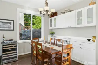 Dining Area:  This bright dining space blends style and practicality with built-in cabinetry and  glass-front storage, ready for entertaining. Sunlight filters through the large window, creating an inviting spot to enjoy a meal or unwind with good conversation.