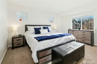 Primary Bedroom:  Bathed in natural light, the primary bedroom offers a calm and relaxing atmosphere. Clean lines and soft tones create a sense of openness, while large windows capture peaceful views and bring a bright, airy feel to this private retreat.