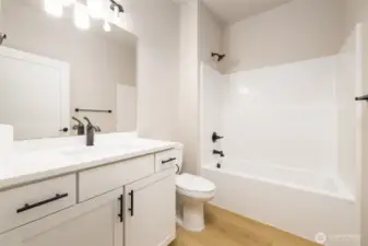 The main bath has taller cabinets, comfort height toilets & quartz countertops.