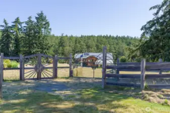 Gates into the approx 2 deer fenced acres with main home, greenhouse, garden & orchard.