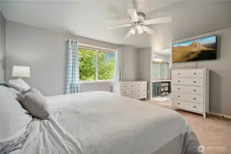 Dual dressers and TV nook lead directly into a luxurious bathroom.