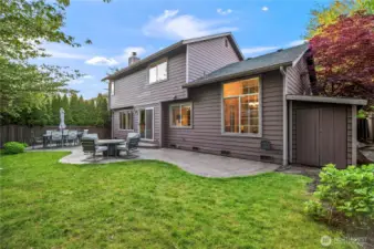 Spacious, fully fenced backyard with lush lawn and custom stamped patio—ideal for entertaining, relaxing, or weekend grilling.