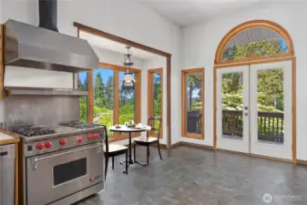The spacious kitchen has a breakfast nook, Chef's Wolf stove & gas range, and lovely wood casings around the windows.