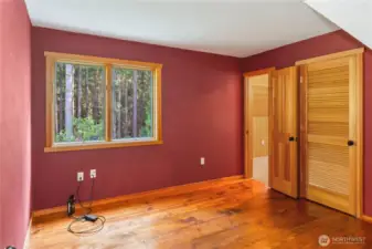 The second guest bedroom with beautiful wide-plank wood floors. There's a walk-in closet on the right. The open door leads to the Bonus room above the garage, which is a pretty cool space.