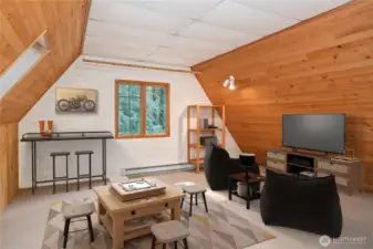 The bonus room above the garage is virtually staged as a game room, and you can use it to suit your needs. Note the baseboard heater along the wall is not functioning.