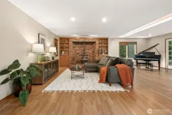 Open to the kitchen, the family room provides a relaxed gathering space that feels both airy and connected. The seamless flow between spaces makes it ideal for daily living and entertaining alike. A Pellet Stove is both convenient and practical for colder days. The space is spacious and lends itself to splitting the use as seen here as a sitting area and music room. A unique skylight brings in additional natural light to the rooms.