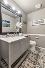 The updated main floor powder room features fresh finishes and a modern vanity. Guests will appreciate its elegant simplicity and convenient location.