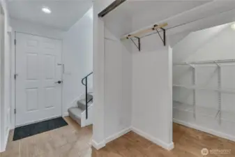 Large pantry under the stairs doubles as coat closet.