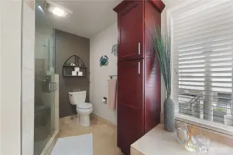The primary bath is a spa-like haven designed for ultimate relaxation, seamlessly blending luxury with the beauty of its waterfront views. The custom walk in shower features a modern glass door and elegant tile work in calming natural tones.
