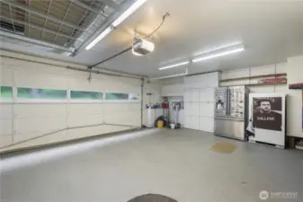 This spacious garage is more than just a place to park-it's a fully functional extension of the home with  a dedicated work area for projects and plenty of cabinents for storage.