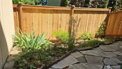 Side yard includes a small garden area—perfect for flowers, herbs, or seasonal veggies
