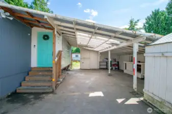 Large lean-to carport area with a little work bench.  Gate access to backyard