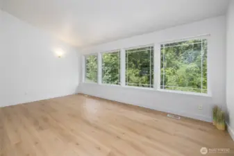 Large windows provide natural light and views of the green space.