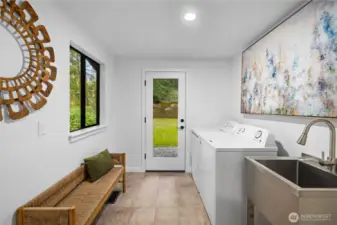 Updated laundry room with new tile flooring, utility sink, and exterior access—designed to handle real life with ease (muddy shoes and all).