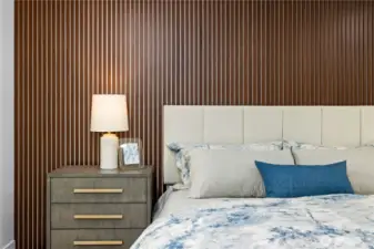 Custom wood feature wall adds warmth, texture, and a modern architectural element to the primary suite.