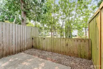 Lush greenery provides a natural barrier along the fence line. A private retreat in the shade!