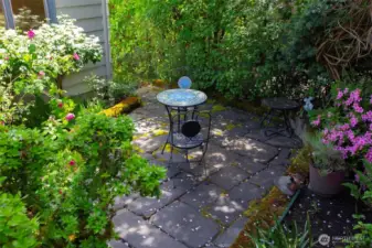 The charming patio, surrounded by flowers, is at the SW corner of the property.
