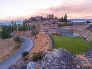 Aerial view of home with grassy lawn area and outdoor living area.