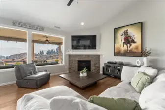 View of Living Room with fireplace and windows looking out over the outdoor living area with lake views.
