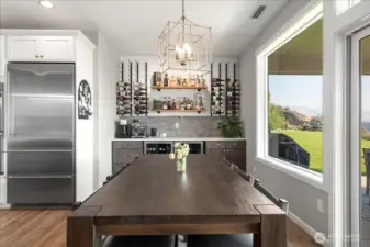 View of dining table with built-in bar with 2 beverage fridges.