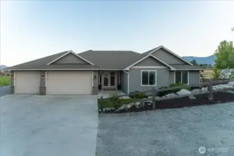 Exterior view of home and landscaping with 3-car garage and French Door entryway.