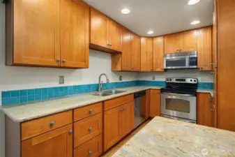 Custom kitchen with eco-friendly Thai Rubber Wood cabinets, granite countertops, ceramic knobs by local artist and stainless appliances.