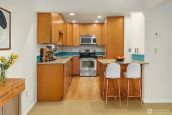 Virtually staged kitchen with stools at breakfast bar.