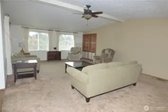 LARGE living room with vaulted ceiling, fan and built ins.