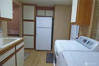 View from the kitchen of the laundry room, back door and more storage.