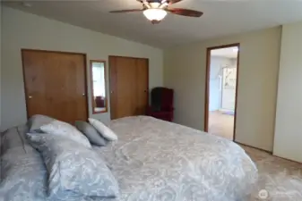 Primary bedroom with double closets, vaulted ceiling and fan.