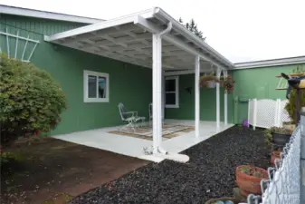 Covered patio with fan. The heat pump is behind the lattice screen.
