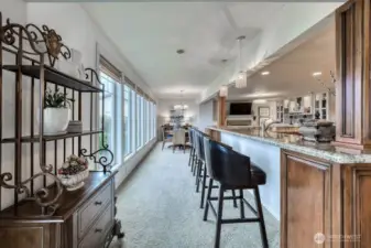 The large sit up bar allows friends and family to visit with the chef, and the chef enjoys stunning views form all of those large picture windows.