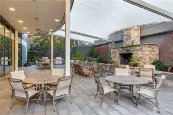 Outdoor patio with multiple grills and large fireplace.