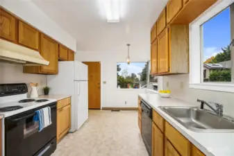 Fabulous galley kitchen with ample storage and an eating nook.  The back deck can be accessed through the door in the photo.