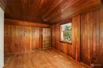 Second bedroom on upper floor offers a small walk-in closet with built-in drawers.