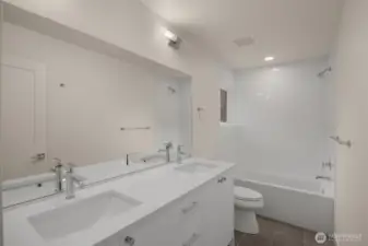 A full-sized second bath with dual sinks and a tub-shower combo is ideal for shared living.