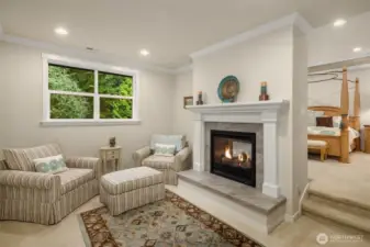 Upstairs, the luxurious primary suite has a two-sided gas fireplace that serves both the private sitting room and the bedroom area.