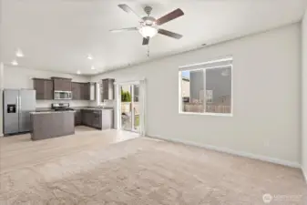 Open concept living, dining, and kitchen. (Carpet replaced since photo taken)