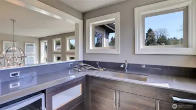 o The kitchenette has an ample countertop, stainless sink, beverage refrigerator, and it is ready for the built-in microwave.