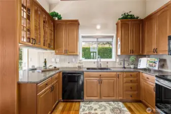 A bright and airy kitchen with ultra high ceiling, rich wood cabinetry, and modern finishes.