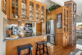 Kitchen is enhanced by the beautifully crafted custom cabinetry with glass displays, and a convenient breakfast bar - perfect for casual meals or chatting with the cook.